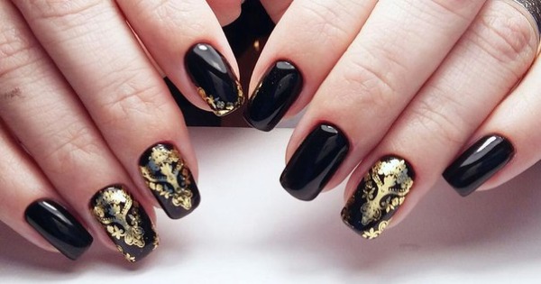 Conception d'ongles en noir, avec vernis noir, or, argent, strass. Nouveaux objets et photos