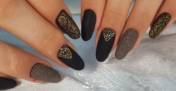 Conception d'ongles en noir, avec vernis noir, or, argent, strass. Nouveaux objets et photos