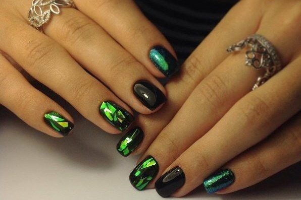 Conception d'ongles en noir, avec vernis noir, or, argent, strass. Nouveaux objets et photos