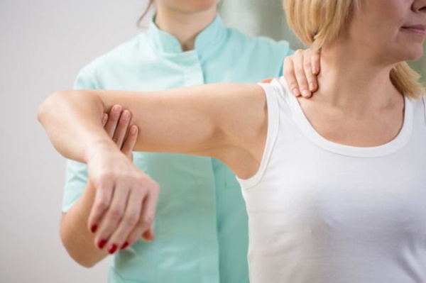 Exercice d'épaule pour les filles dans le gymnase. Tutoriels vidéo, photo