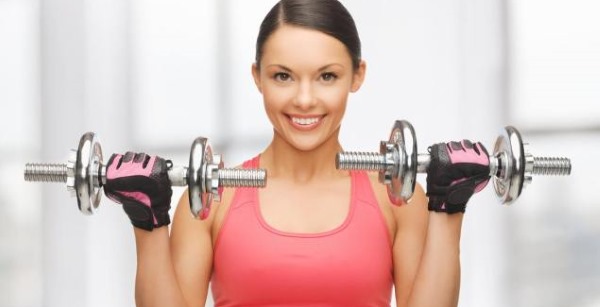 Exercices avec des haltères sur la poitrine pour les filles dans la salle de gym, à la maison