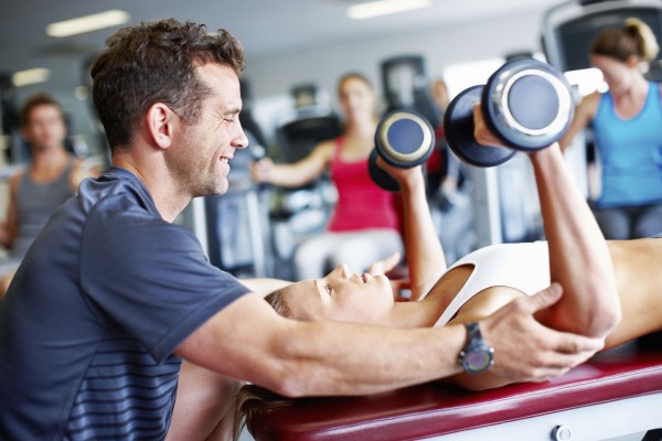 Exercices avec des haltères sur la poitrine pour les filles dans la salle de gym, à la maison