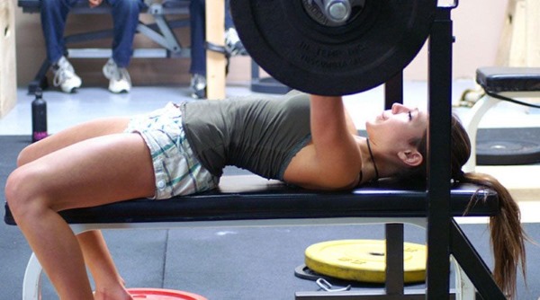 Exercices sur la poitrine dans la salle de gym pour les filles avec et sans haltères, sur la barre horizontale