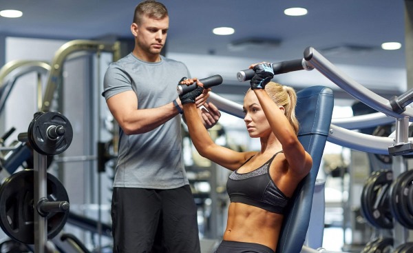 Cours avec un entraîneur dans la salle de sport pour filles. Quels sont les avantages individuels, collectifs et