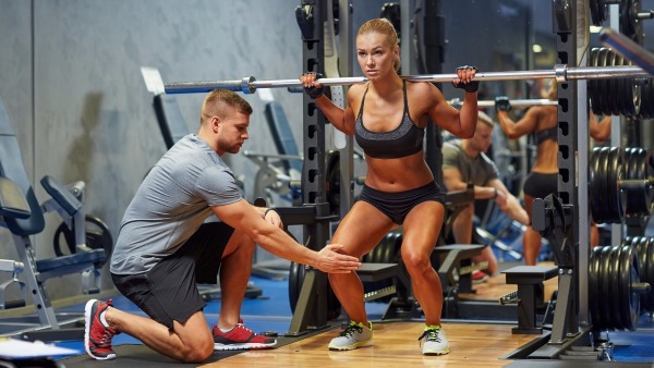 Smith squat pour les filles. Technique d'exécution sur les fesses, les genoux, une jambe, les quadriceps, frontale avec une position étroite et large